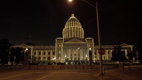 arkansas state capitol in little rock arkansas at night with holiday lights on the building with medium shot tilting down