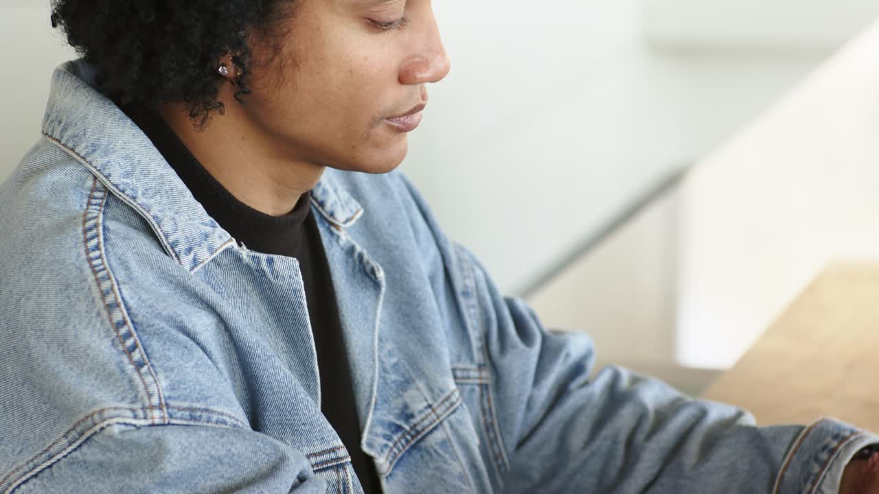 Opening shot of hands typing, camera panning upward revealing man typing at laptop near coffee mug