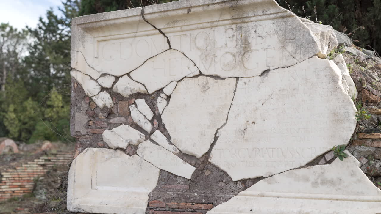 Remains of Latin inscribed marble wall at the ancient Roman archaeological site of Ostia Antica in Italy.