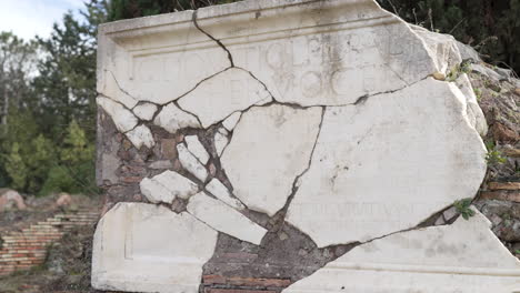 remains of latin inscribed marble wall at the ancient roman archaeological site of ostia antica in italy.