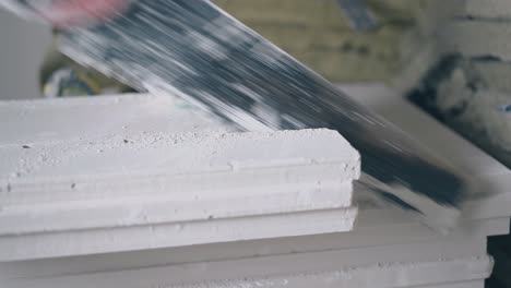 skilled-painter-in-gloves-saws-white-gypsum-plasterboard