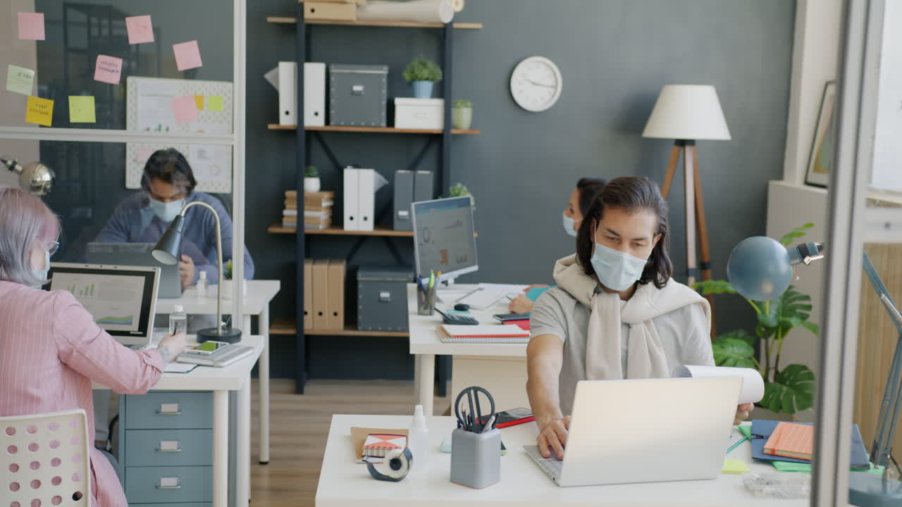 Employees working in a modern office with social distancing