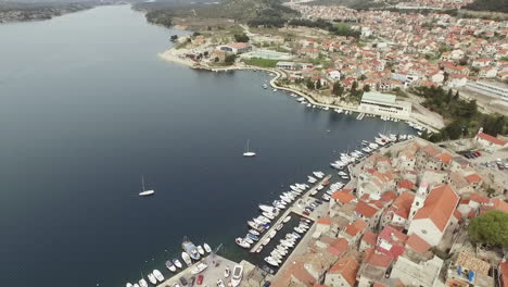 Flying-over-the-city-of-Sibenik,-panoramic-view-of-the-old-town-center-and-coast