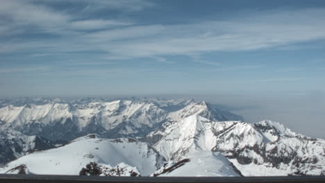 panorama of snow covered peaks of swiss alps above a sea of clouds, or nebelmeer. archival footage shot from the piz gloria observation deck. slow pan. schilthorn bernese oberland switzerland 1970s