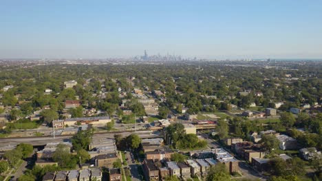 drone descends in chicago's southside with view of skyline in distance