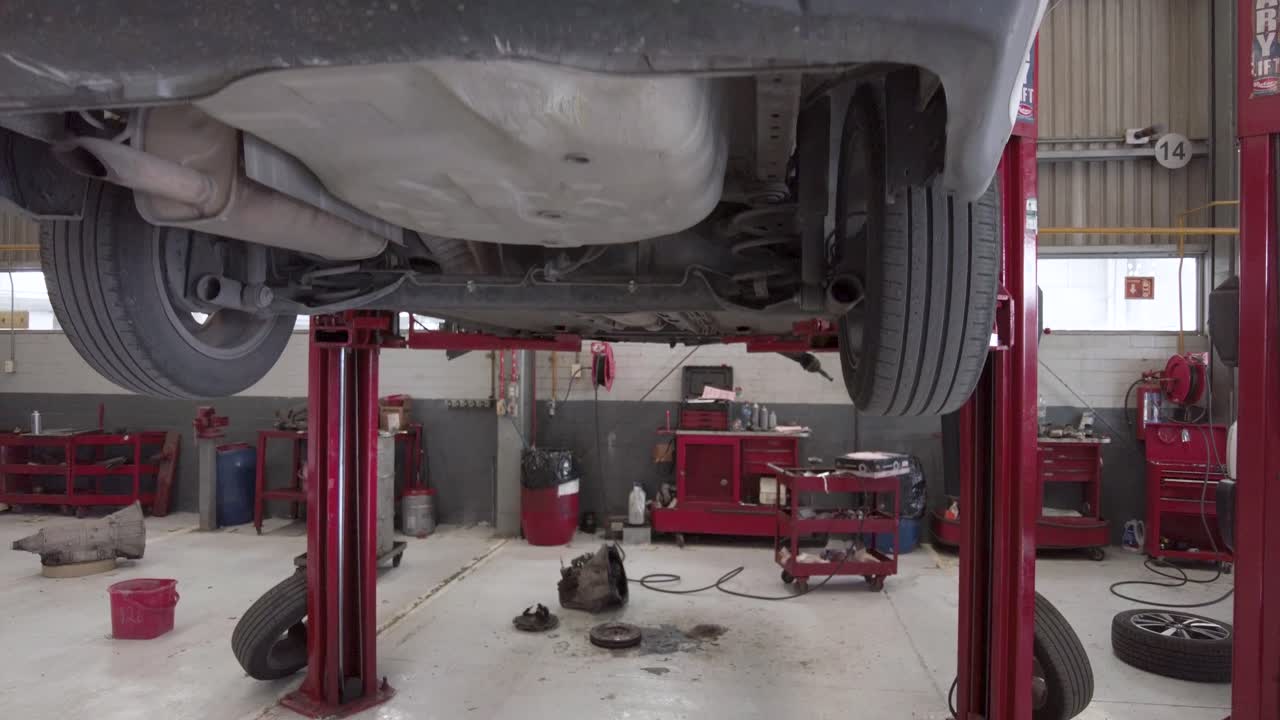 A car suspended on a car lift waiting for service at a workshop station garage at mexico latin-america