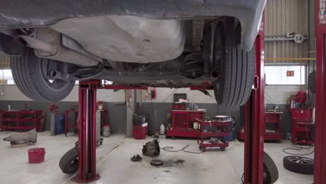 a car suspended on a car lift waiting for service at a workshop station garage at mexico latin-america