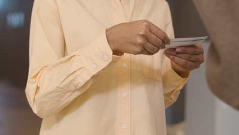 close up of an female usher checking and tearing movie tickets of a couple at the cinema