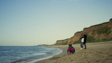 familia joven disfruta de vacaciones en la playa del océano naturaleza. niño juega con los padres al aire libre