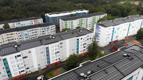 Modern-living-apartment-buildings-with-solar-panels-on-top,-fly-over-drone-view