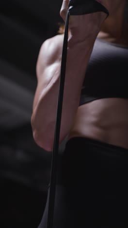 vertical video close up shot of mature woman wearing gym fitness clothing exercising with resistance band