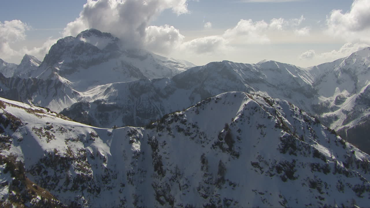 dolly aéreo disparó por encima de un pico de montaña que revela los grandes alpes nevados en italia