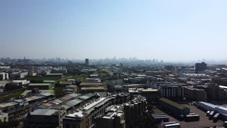 A-sprawling-cityscape-under-clear-skies,-showing-dense-urban-structures,-aerial-view