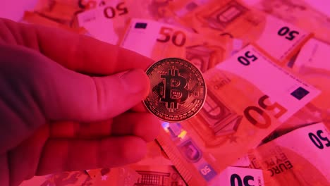 Bitcoin held in hand against spinning euro cash of red light, symbolizing crisis