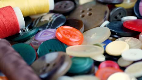 sewing buttons. close-up. rotation. various round colored sewing buttons rotate on turntable. loop motion background. concept of color, fashion, dressmaking, sewing, tailor