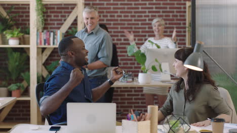 happy african american businessman cheering excited celebrating success victory business team enjoying congratulating colleague in diverse office workspace