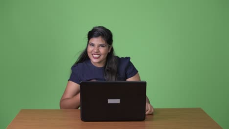 joven sobrepeso hermosa mujer de negocios india contra fondo verde