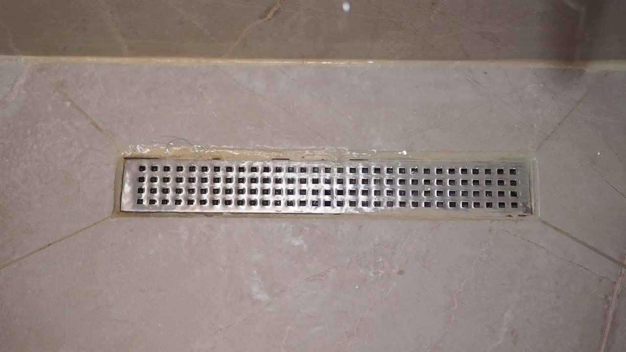 Water Draining into a Modern Linear Shower Drain