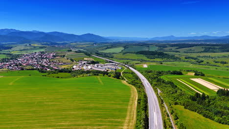 green fields and winding roads. vibrant fields span the landscape, while a highway cuts through the serene countryside and distant mountains
