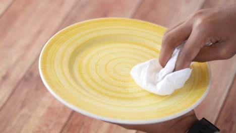 close up of young man wiping plate with a cloth