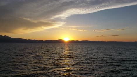 flying over calm ocean with beautiful sunset in the background