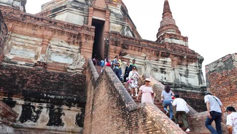 visitors ascend ancient temple steps in ayutthaya, thailand