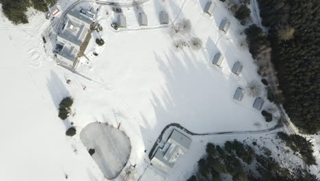 aerial shot of winter ski camp with lodge cabins, snow covered alpine landscape