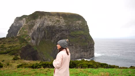 woman with winter clothes in azores looking around in morro do castelo branco