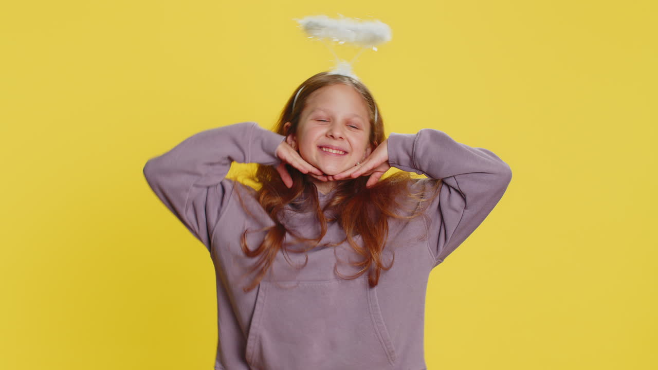 Portrait of smiling shy angelic child girl with angel halo nimb over head positive love emotions