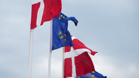 Flags-of-Denmark-and-European-Union-waving-on-windy-cloudy-day