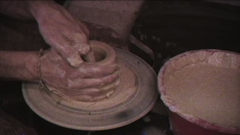 the potter makes a jug of clay. vintage effect. a man makes a vase on a potter's wheel