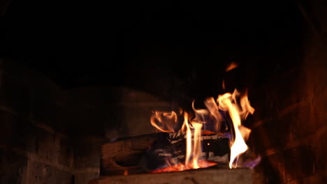 wood burning in stone fireplace. burning fireplace. glowing fire in the stone fireplace to warm at night. cozy evening near the fire at home at winter holidays.
