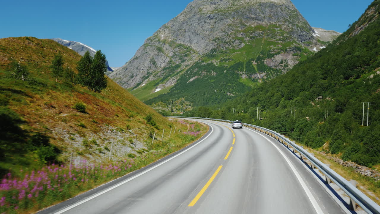 노르웨이 1인칭 시점의 산들 사이의 경치 좋은 길을 따라 가다