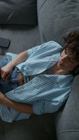 woman relaxing on couch with headphones