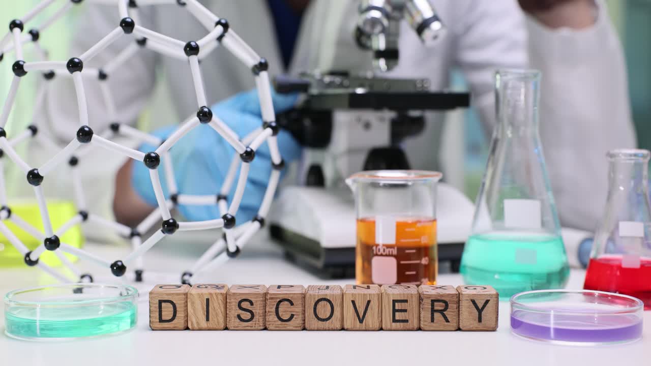 Discovery Word Blocks on Lab Table with Scientist and Microscope