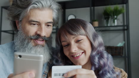 couple shopping online with mobile and credit card