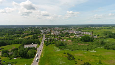 drone aerial view of zarasai city, lithuania, road traffic residential buildings and green landscape on sunny summer day