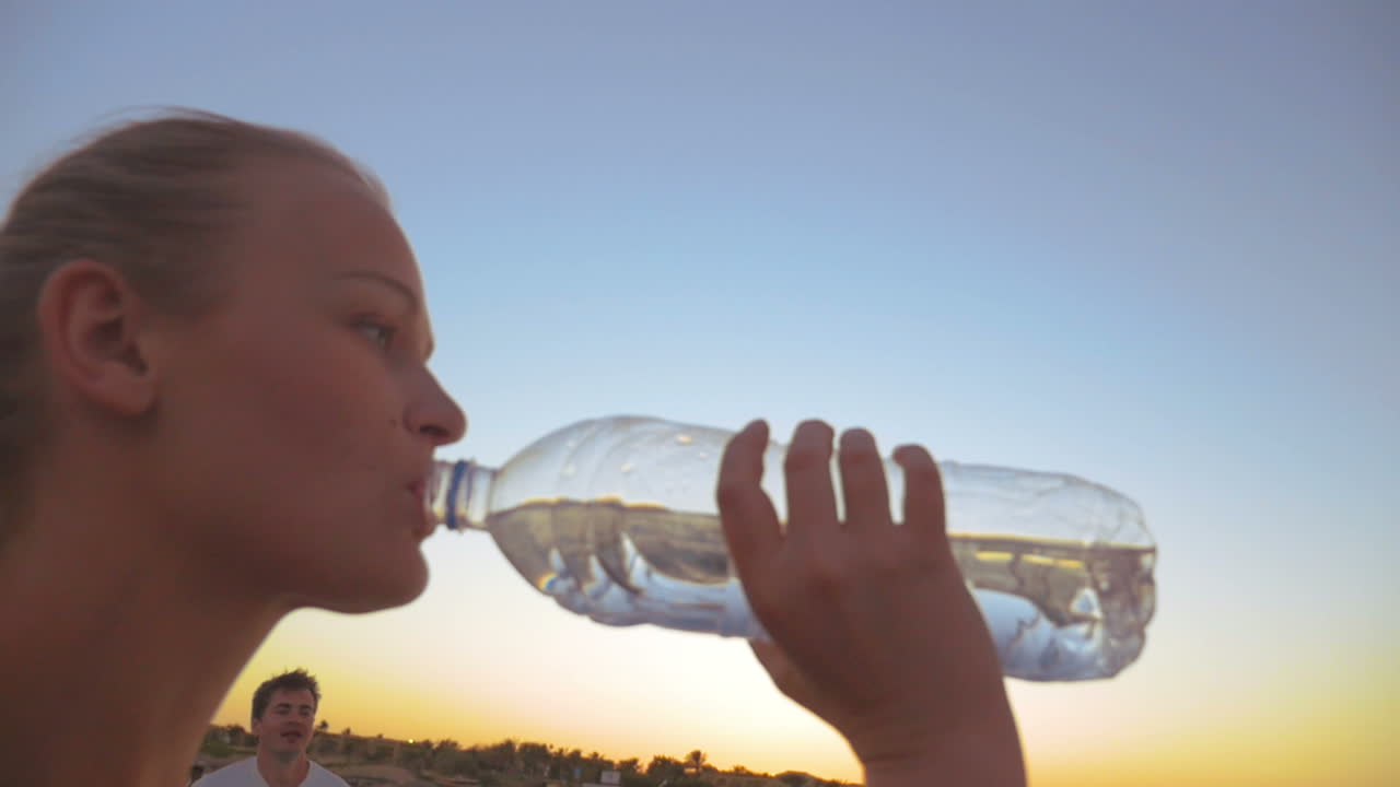 hombre y mujer bebiendo agua al aire libre