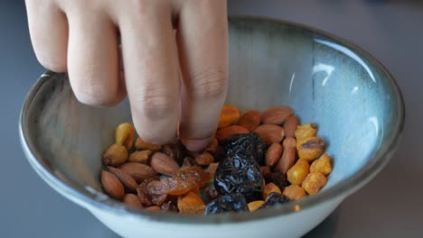 mix of nuts, raisins, and dried plums in a bowl