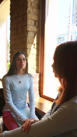 two women talking in a cafe