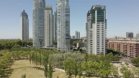 Flug-über-üppigen-Bäumen-In-Richtung-Moderner-Bürogebäude-In-Puerto-Madero,-Buenos-Aires,-Argentinien-–-Niedrige-Luftaufnahme