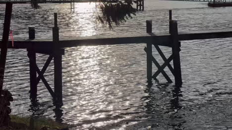 Silhouette-Des-Piers-Auf-Dem-Wasser-Bei-Sonnenuntergang,-Nahaufnahme