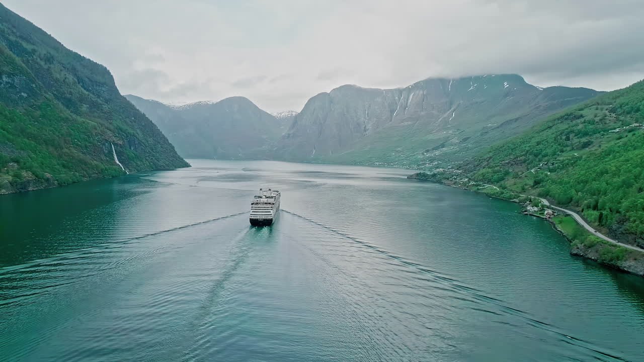 Kreuzfahrtschiff in einem tiefen, engen Fjord in Norwegen – eine Luftaufnahme enthüllt die zerklüftete Landschaft.