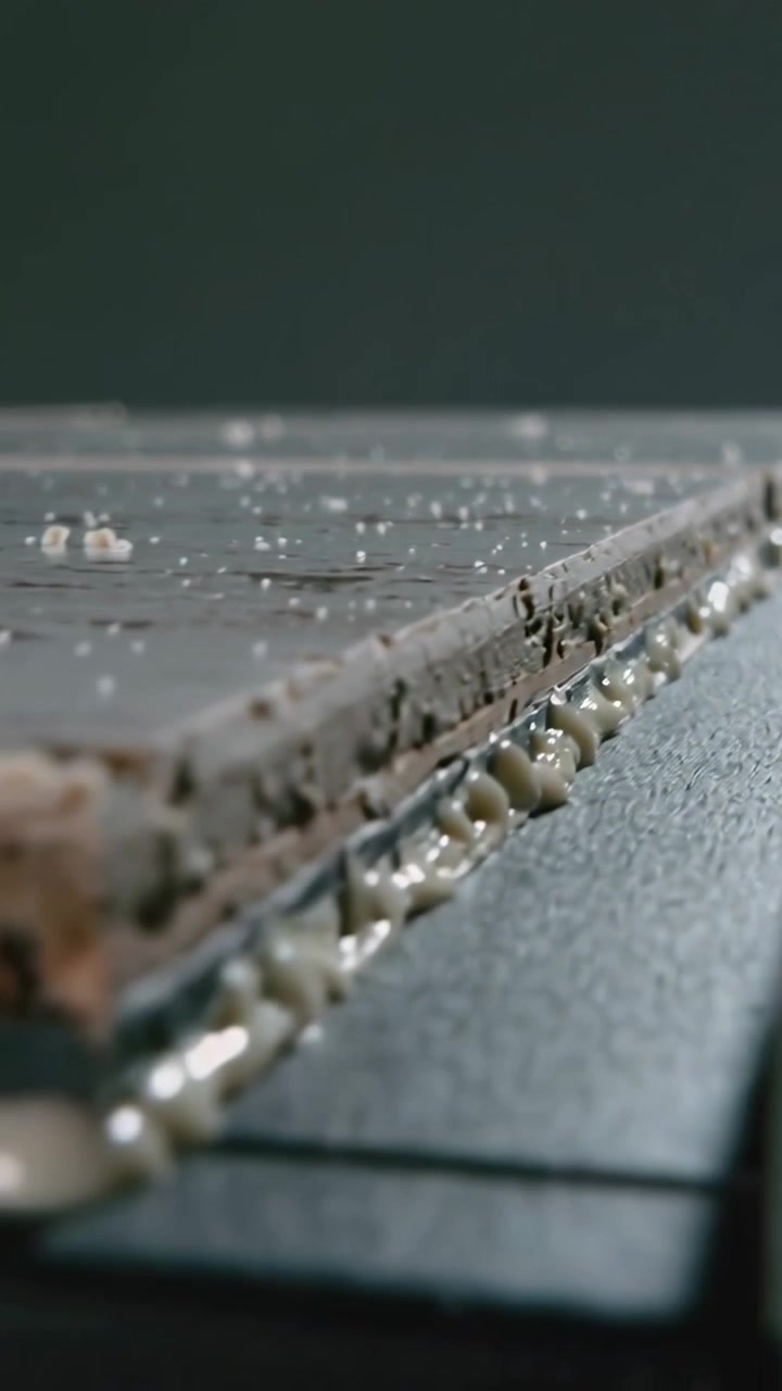 Vertical video: Sliding cam tracking layered panel edge on bench revealing seam