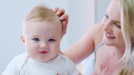 mother lying on bed at home gives baby son kiss