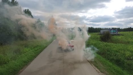 red convertible car with smoke on country road