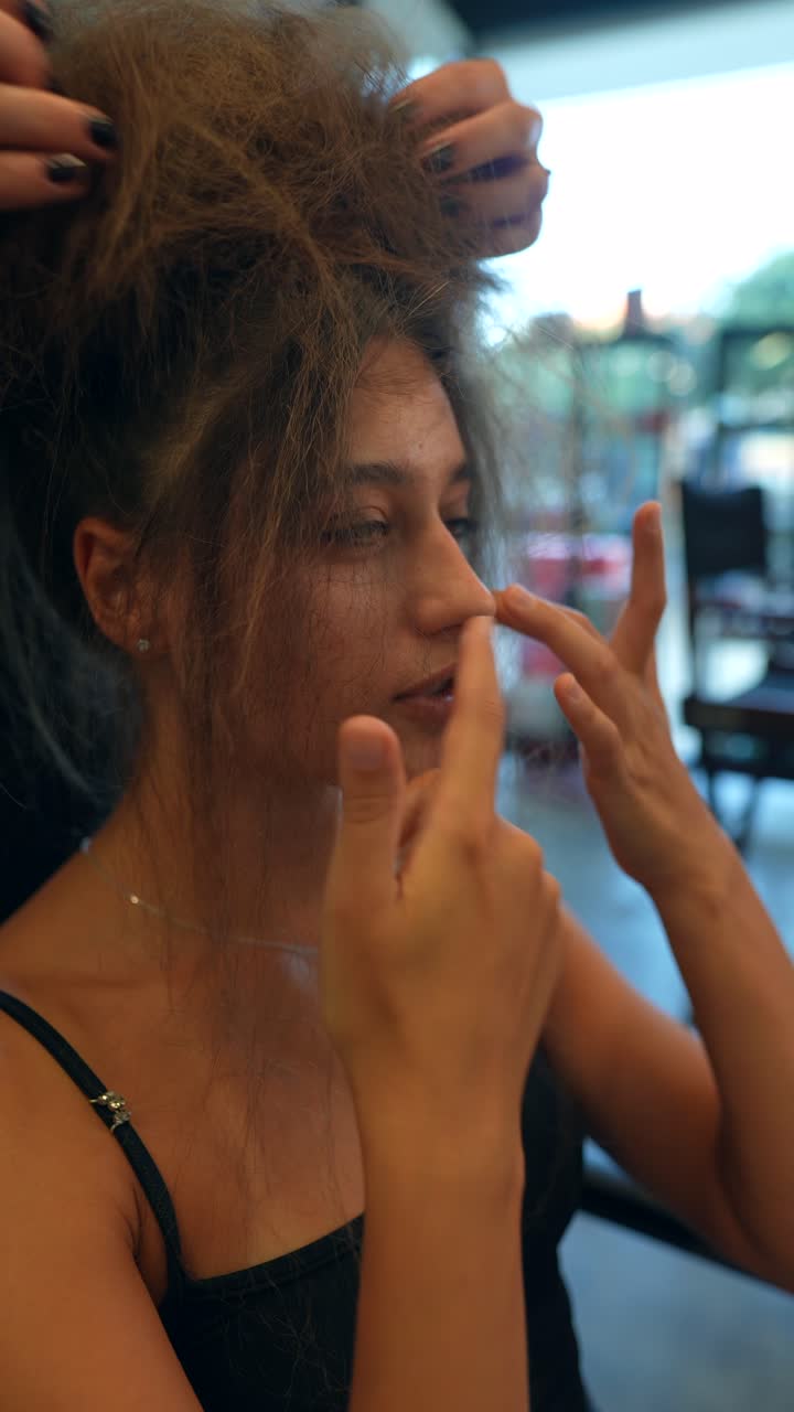 Giovane donna che si fa acconciare i capelli in un salone di bellezza.