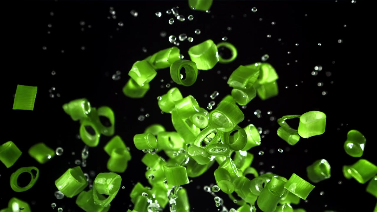 Cebolinhas Verdes Frescas e Gotas de Água Voando em Fundo Preto