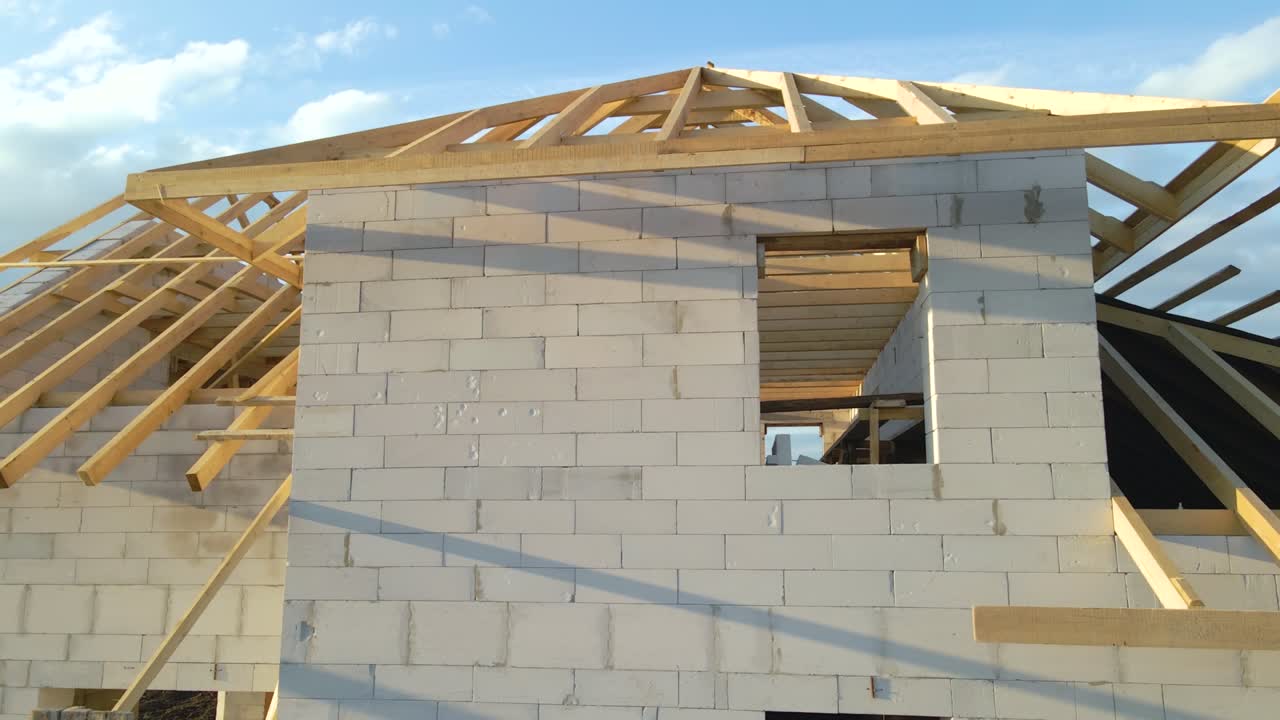 vista aérea del marco inacabado de una casa privada con paredes de hormigón ligero aireado y marco de techo de madera en construcción