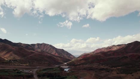 Aerial-drone-shot-of-clouds-panning-down-to-Salt-Lake-City-mountain-range-with-fall-colored-leaves-at-60fps